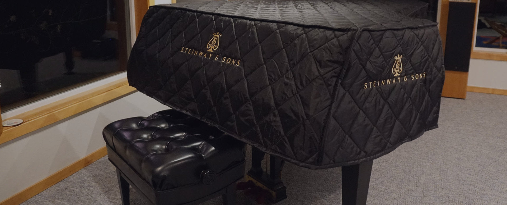 Quilted black grand piano cover on a Steinway grand