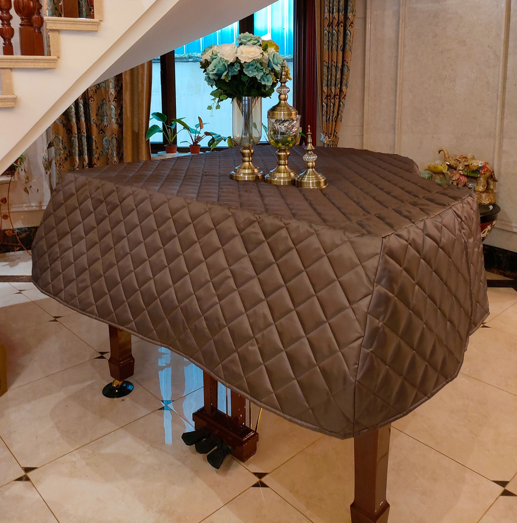 Brown quilted nylon piano dust cover for Yamaha grand piano. Lightweight cover with diamond quilt pattern and side slits for easy keyboard access.