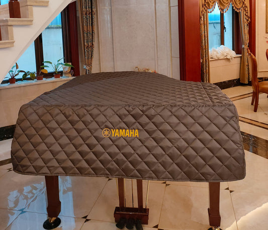 Brown quilted nylon piano dust cover for Yamaha grand piano, shown with custom front embroidery. Lightweight cover featuring diamond quilt pattern, side slits, and personalized embroidered text.